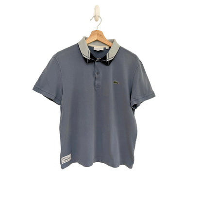Blue polo shirt on a hanger against a beige background