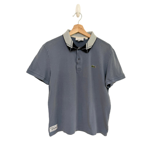 Blue polo shirt on a hanger against a beige background
