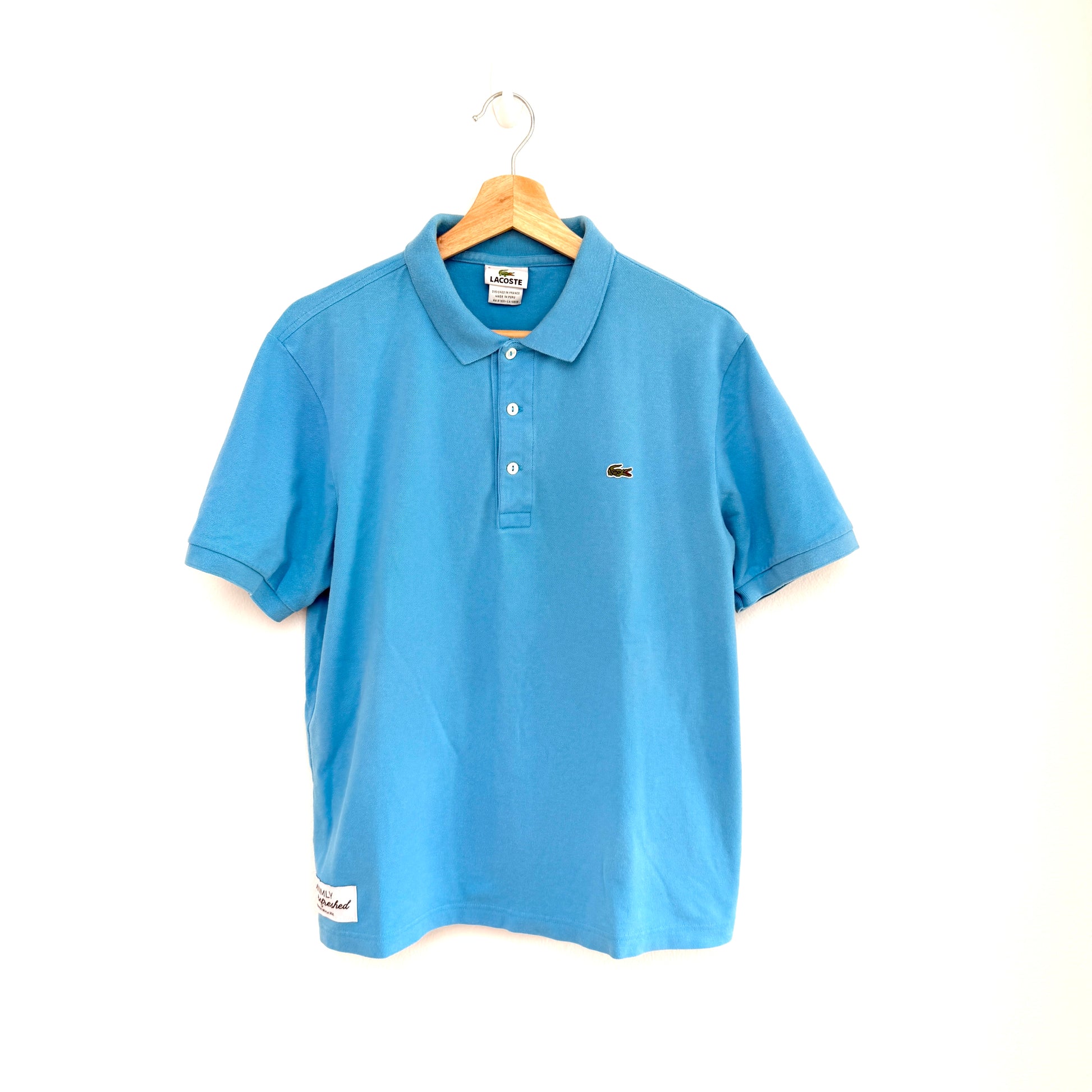 Blue polo shirt on a hanger against a white background