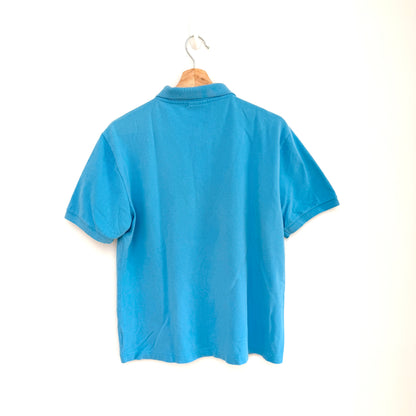 Blue polo shirt on a hanger against a white background