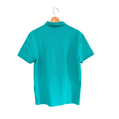 Turquoise polo shirt on a hanger against a white background
