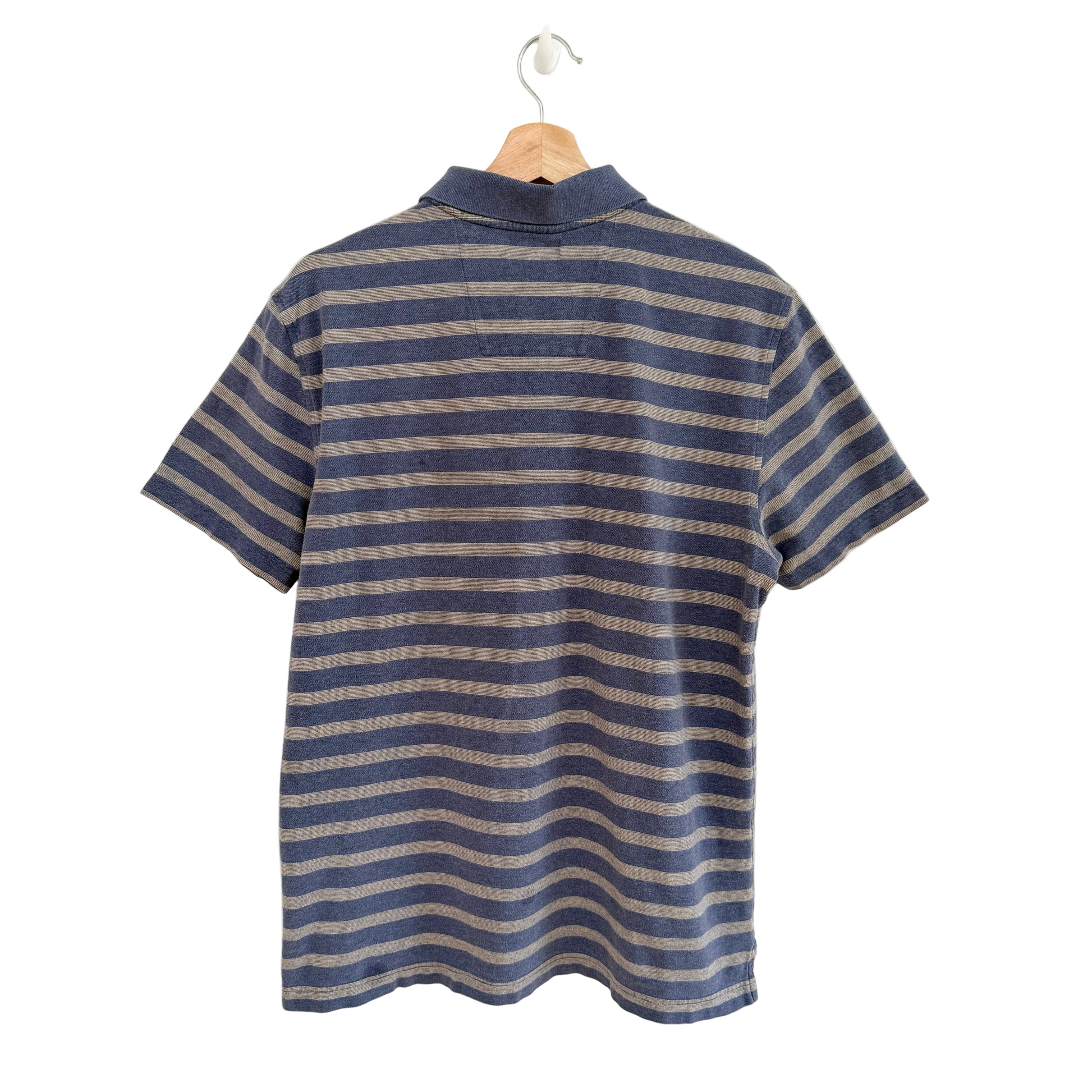Blue and beige striped shirt on a hanger against a white background