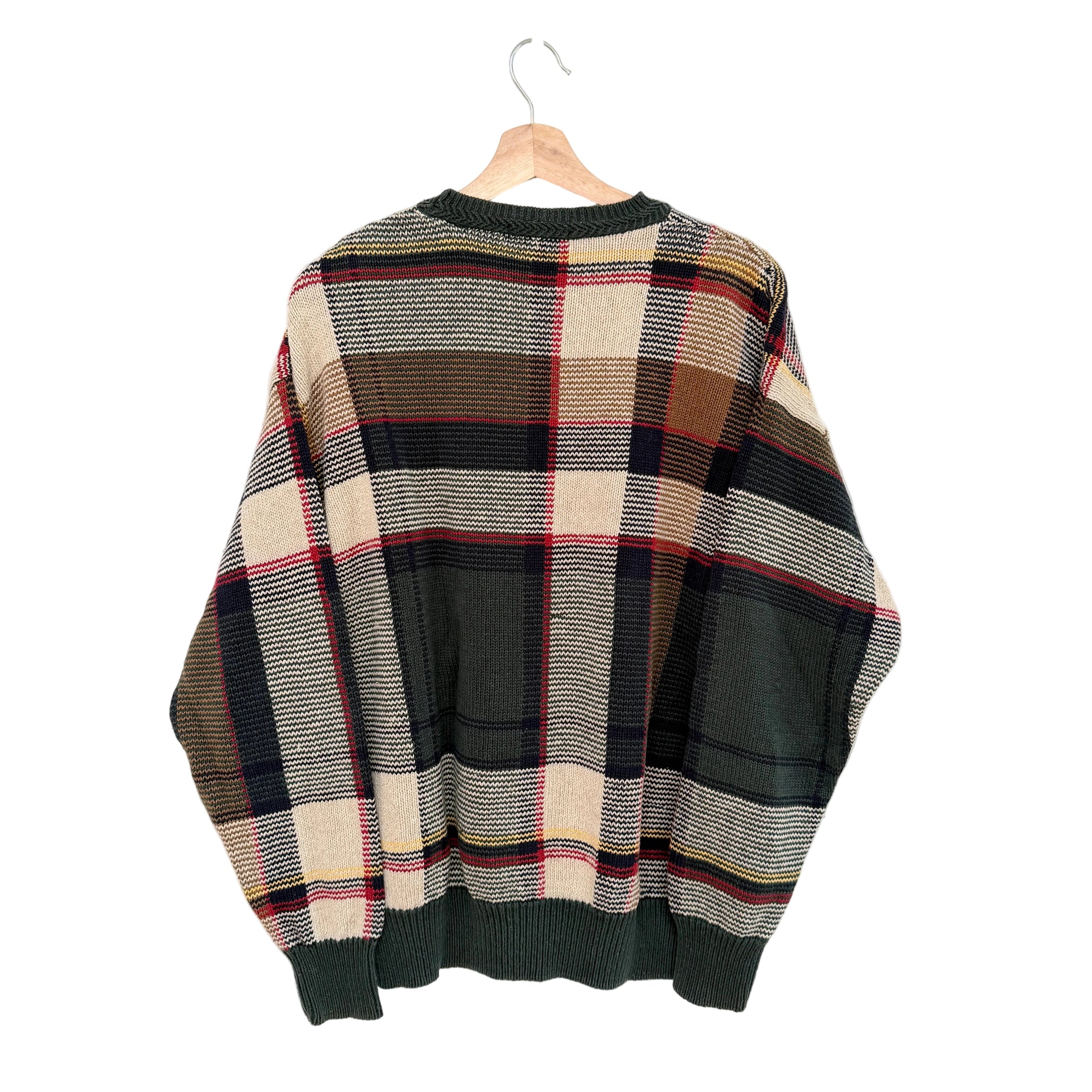 Plaid sweater on a hanger against a white background