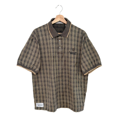 Plaid shirt with brown collar on a hanger against a white background