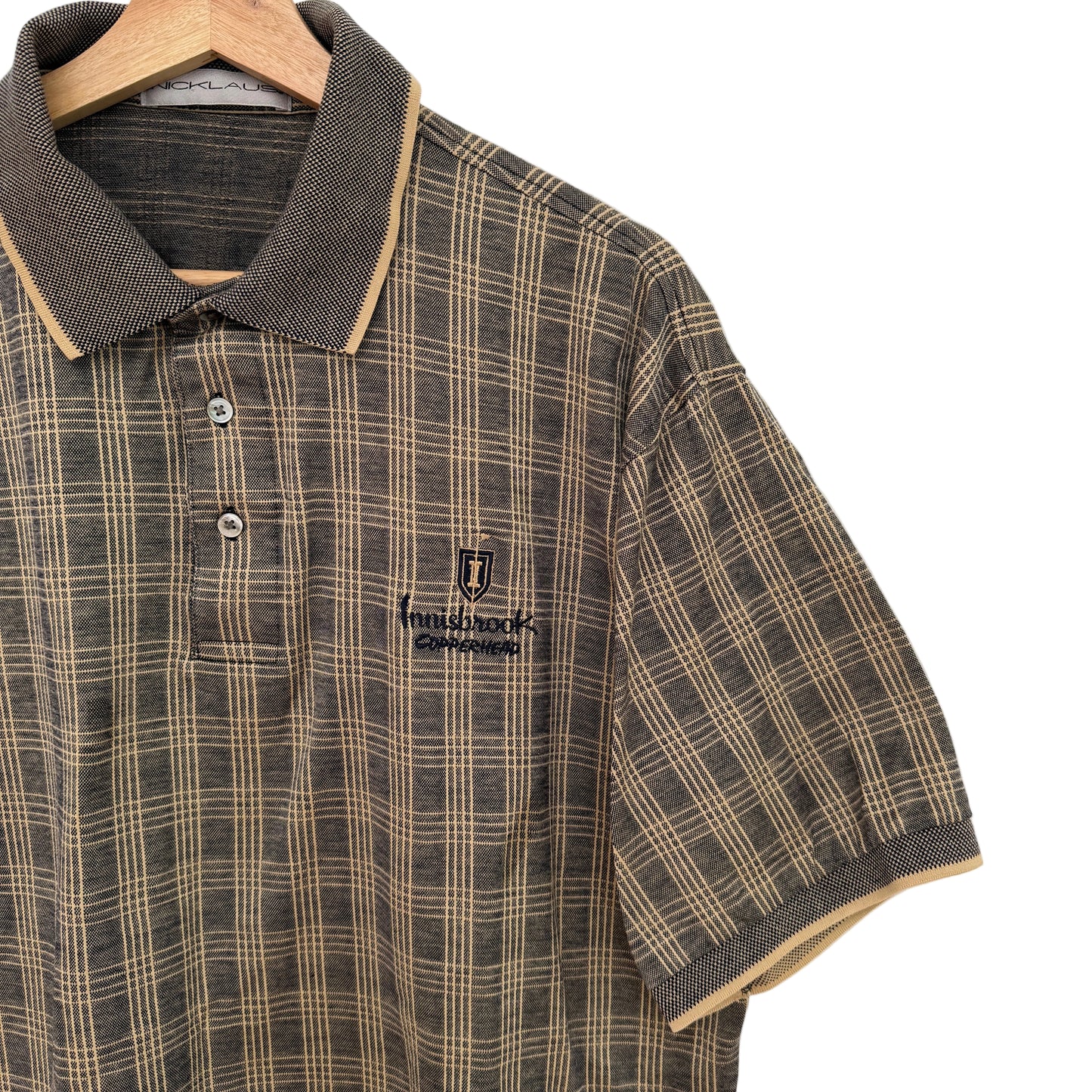 Plaid shirt with a brand logo on a hanger against a white background