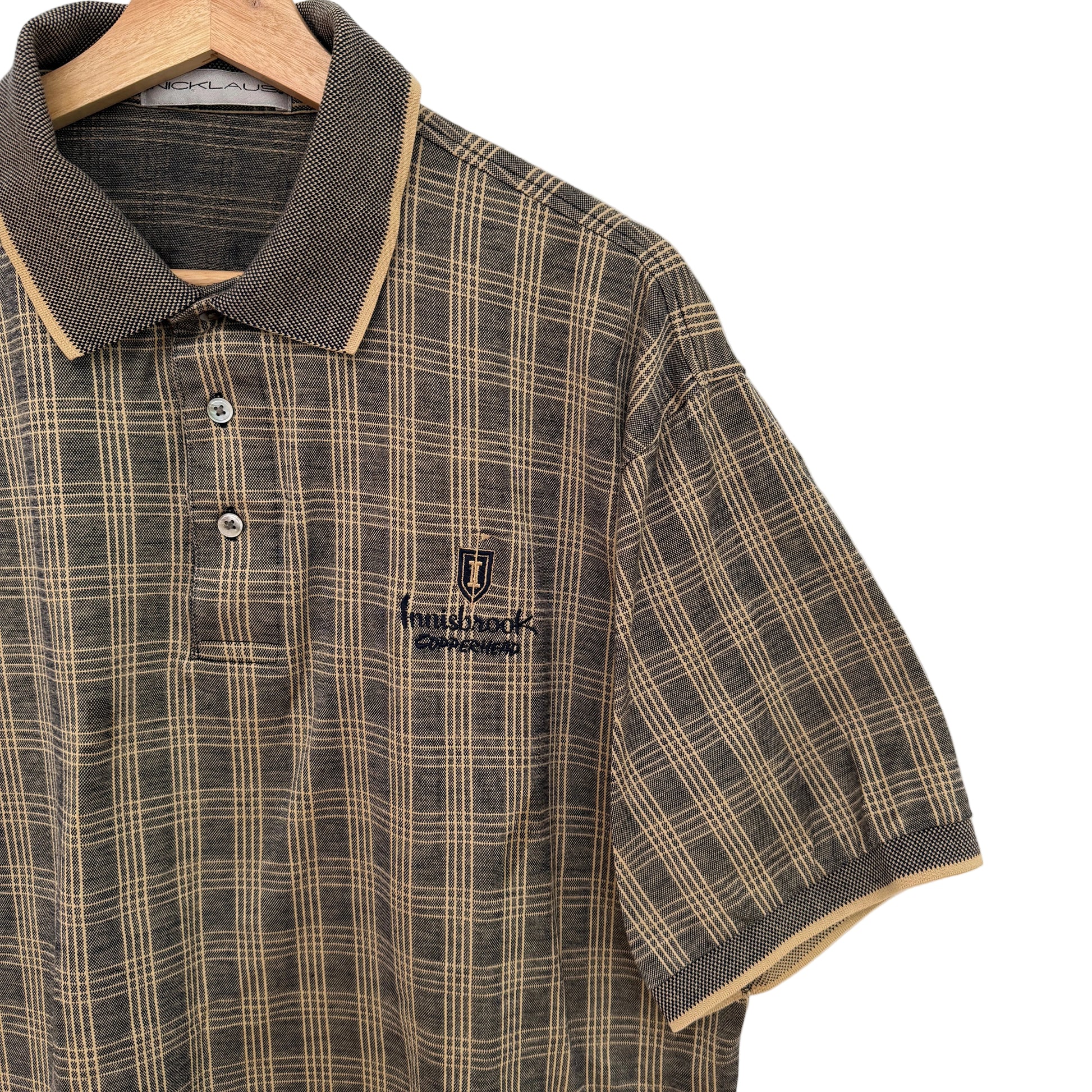 Plaid shirt with a brand logo on a hanger against a white background