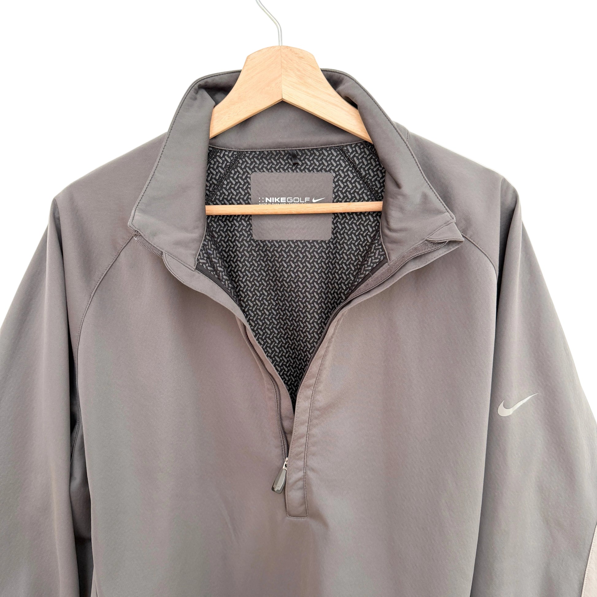 Gray Nike jacket on a hanger with a white background