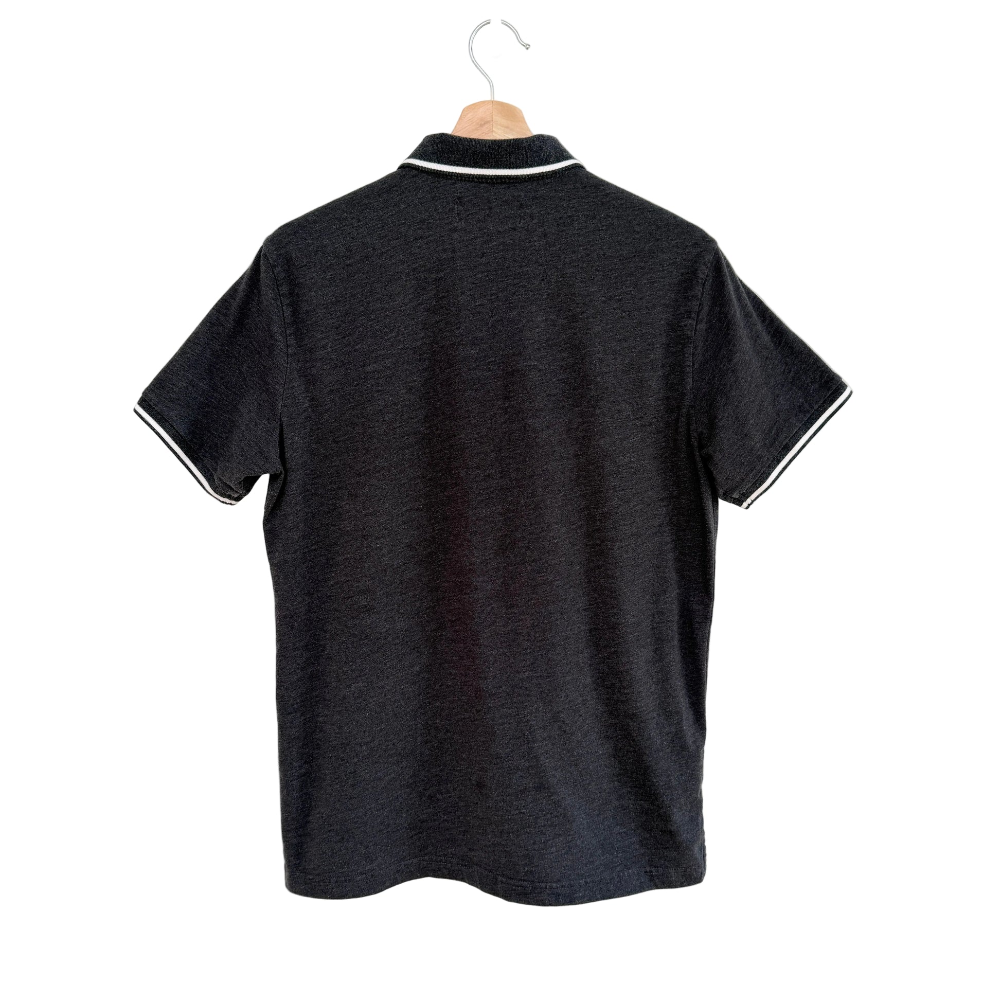 Grey polo shirt with white trim on a hanger against a white background