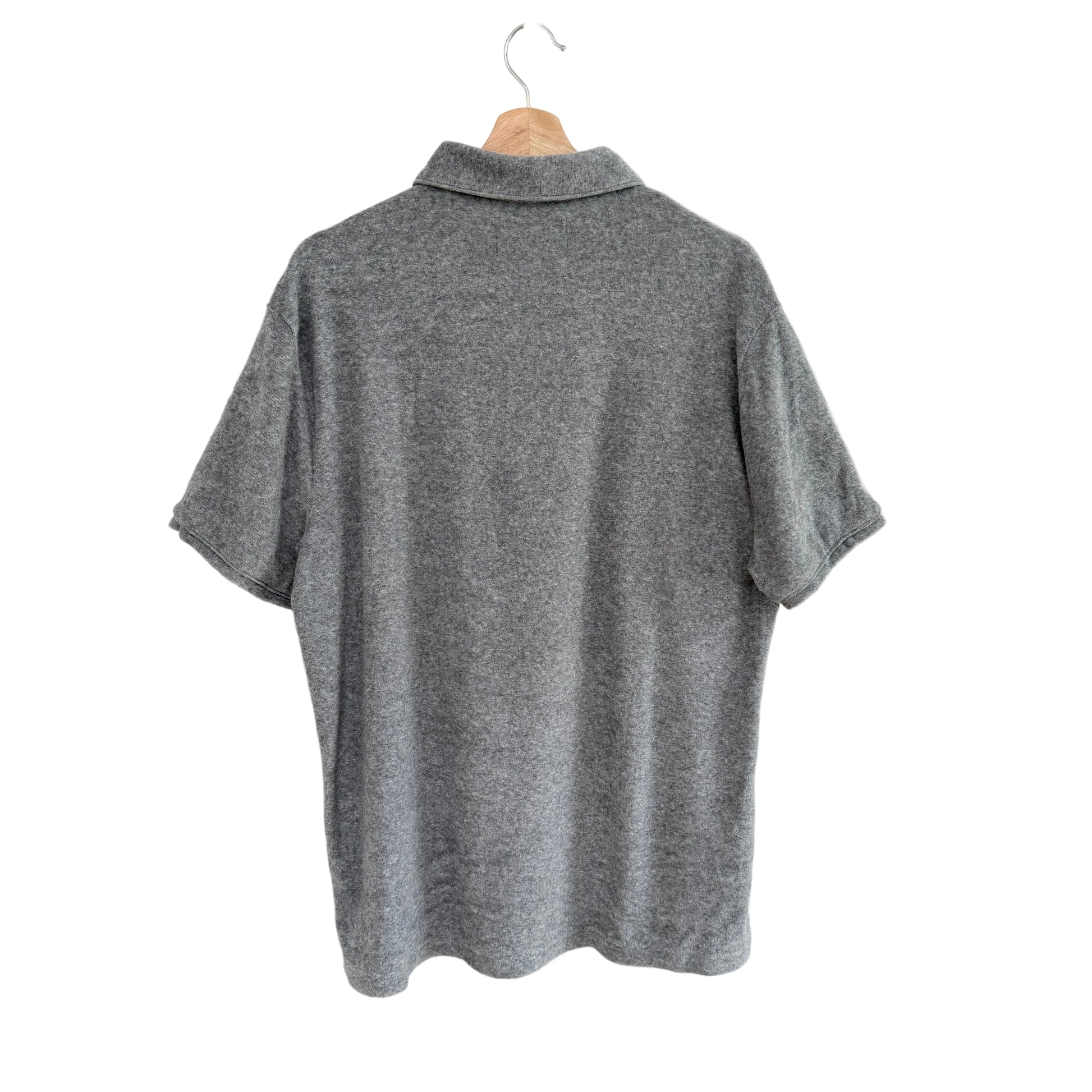 Gray polo shirt on a hanger against a white background