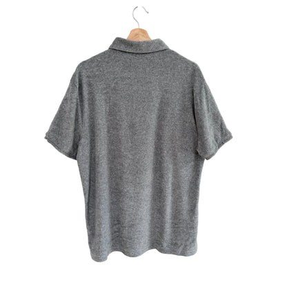 Gray polo shirt on a hanger against a white background