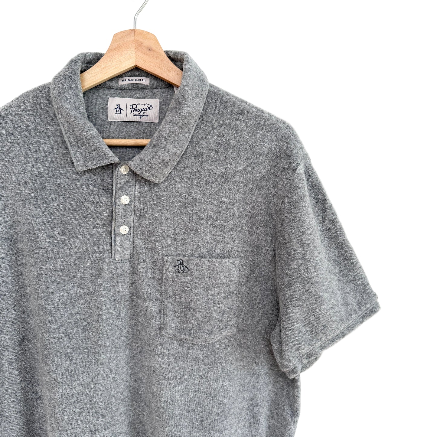 Gray polo shirt on a hanger against a white background