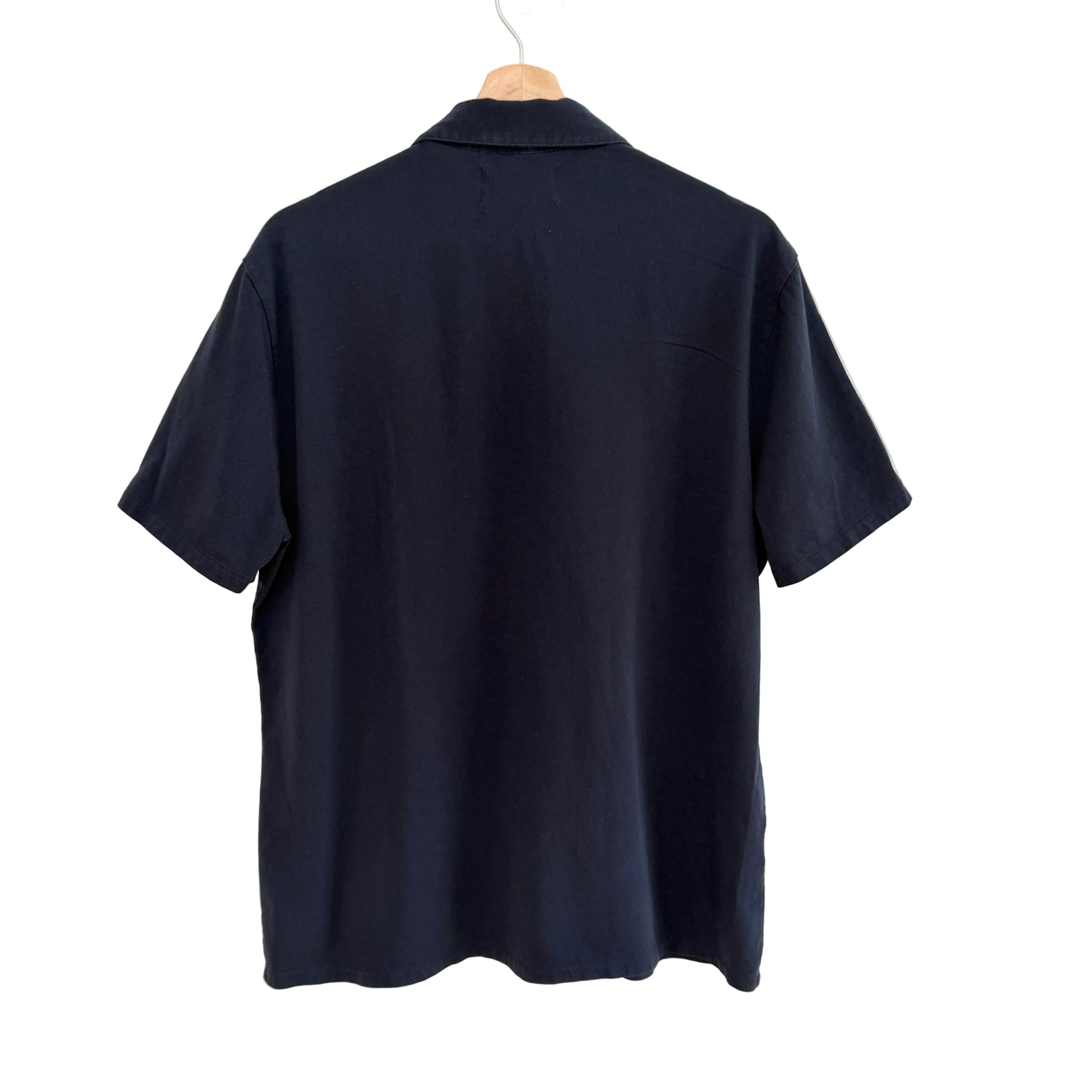 Navy polo shirt on a hanger against a white background