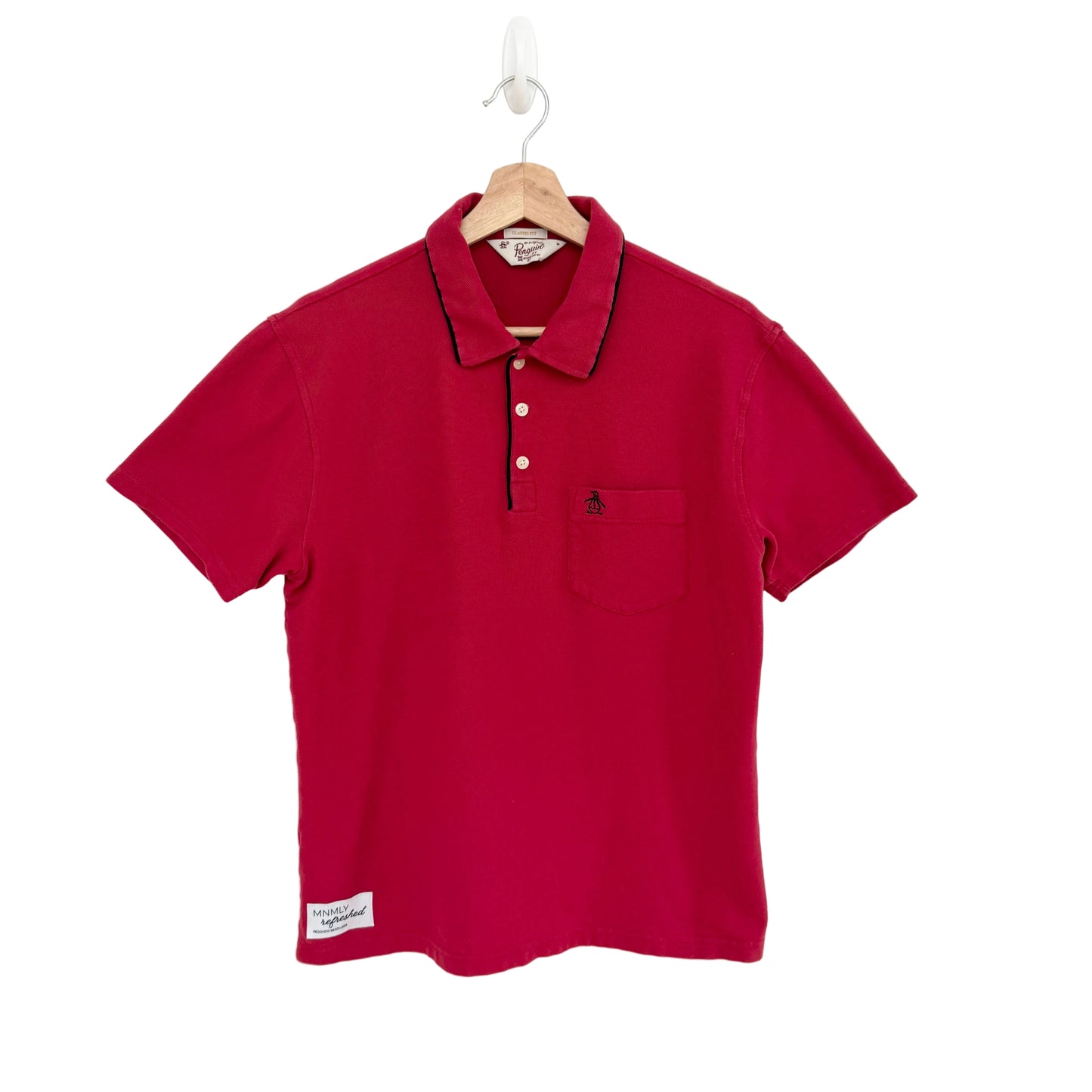 Red polo shirt on a hanger against a white background