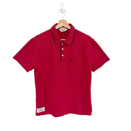Red polo shirt on a hanger against a white background