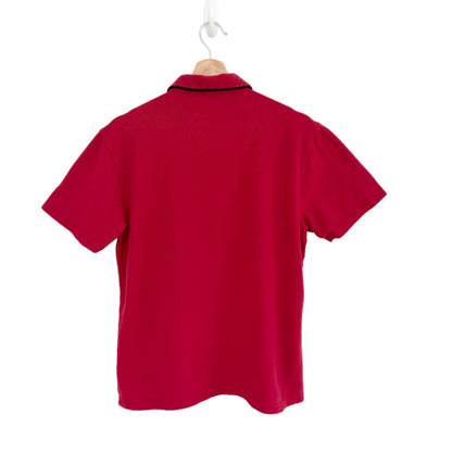 Red polo shirt on a hanger against a white background