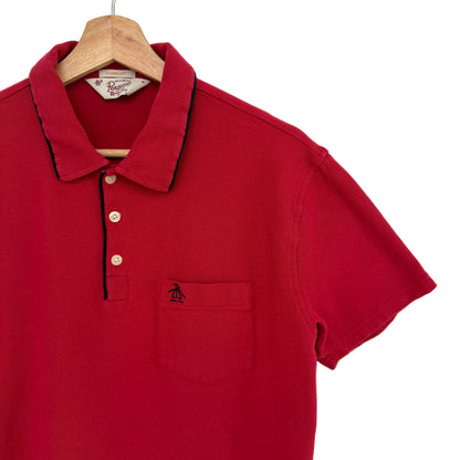 Red polo shirt on a hanger against a white background