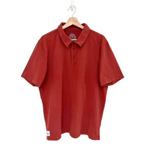 Red polo shirt on a hanger against a white background