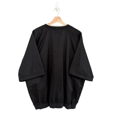 Black oversized shirt on a hanger against a white background