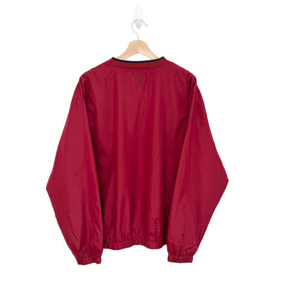 Red windbreaker on a hanger against a white background