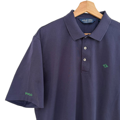 Navy blue polo shirt with green logo on a wooden hanger against a white background