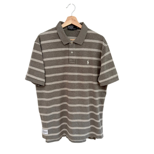 Tan striped polo shirt on a hanger against a white background
