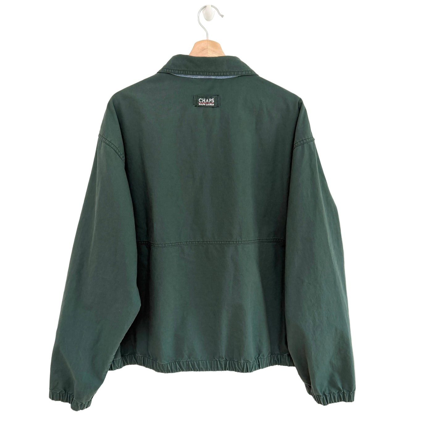 Green jacket on a hanger with a visible brand logo against a white background