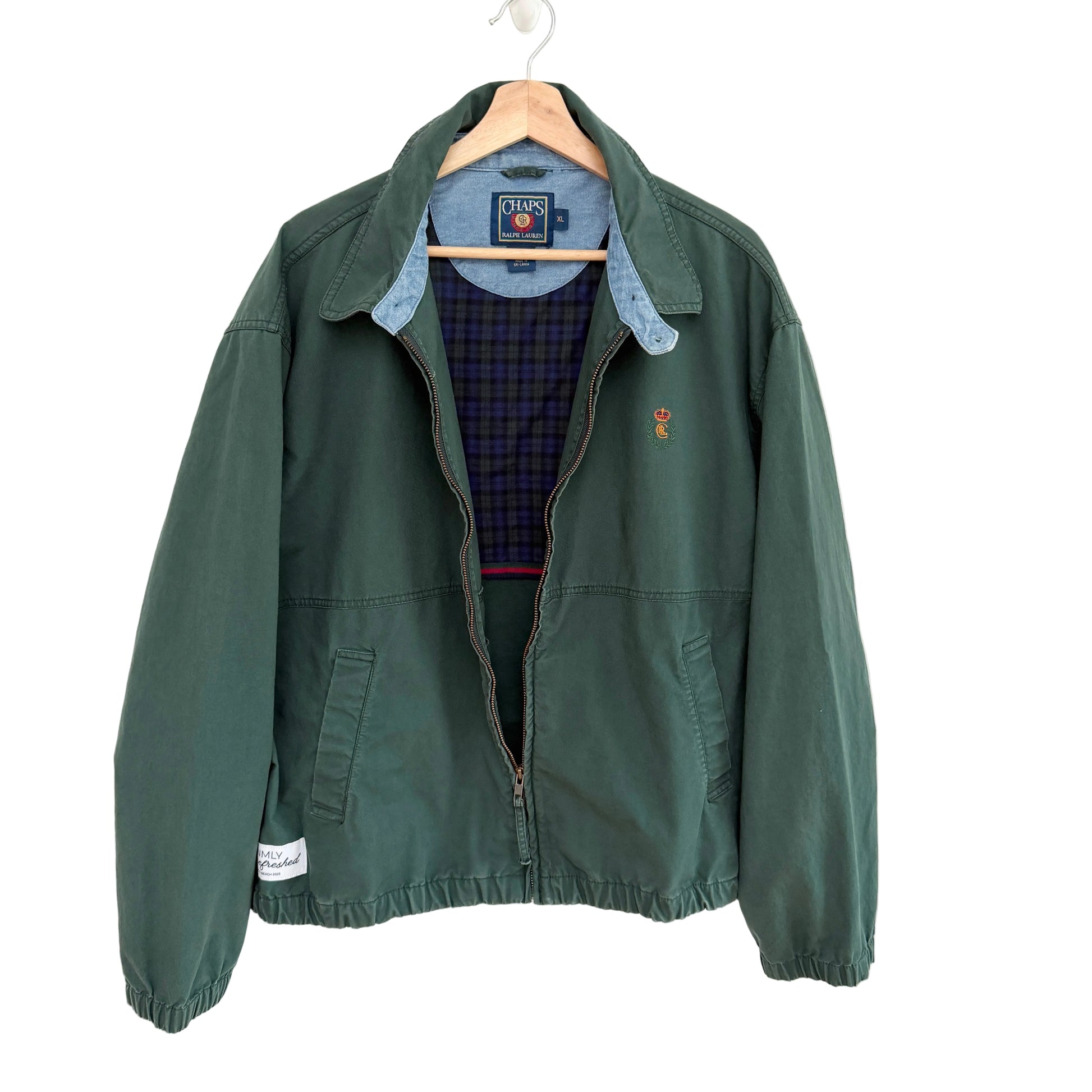 Green jacket with a plaid shirt underneath on a white background