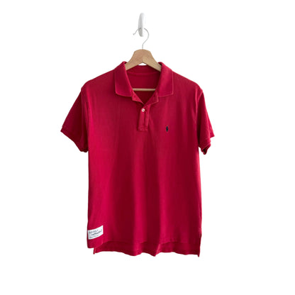 Red polo shirt on a hanger against a white background