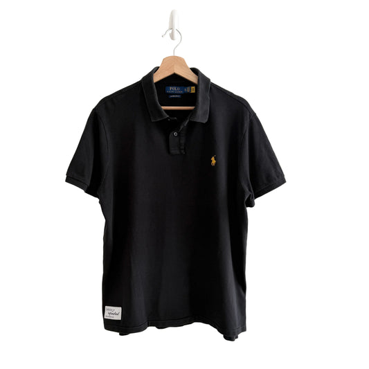 Black polo shirt with Ralph Lauren logo on a hanger against a white background