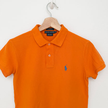 Orange polo shirt with Ralph Lauren logo on a hanger against a white background