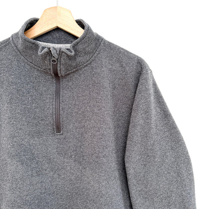 Gray pullover sweatshirt on a wooden hanger against a white background