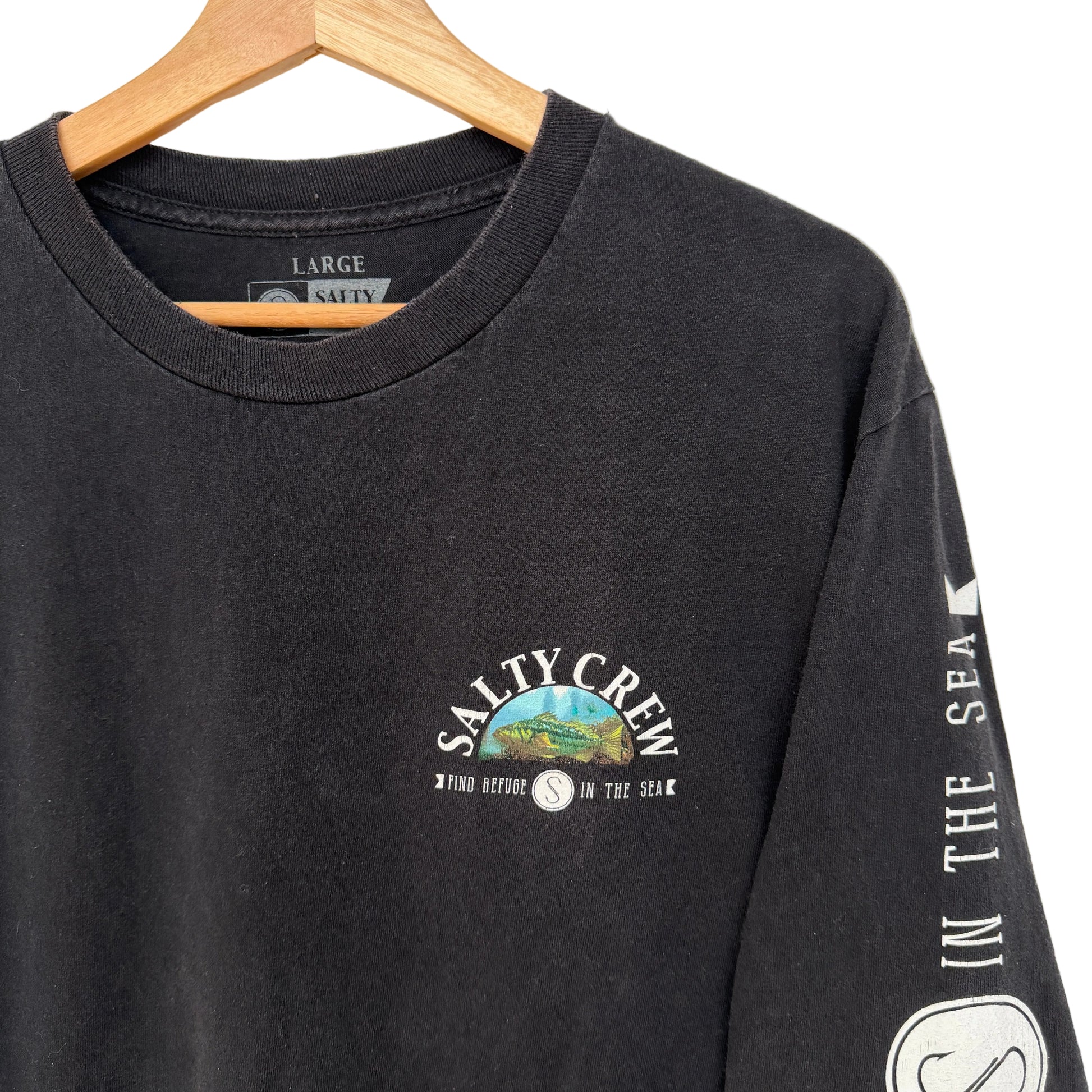 Black long-sleeve shirt with Salty Crew logo on a hanger against a white background