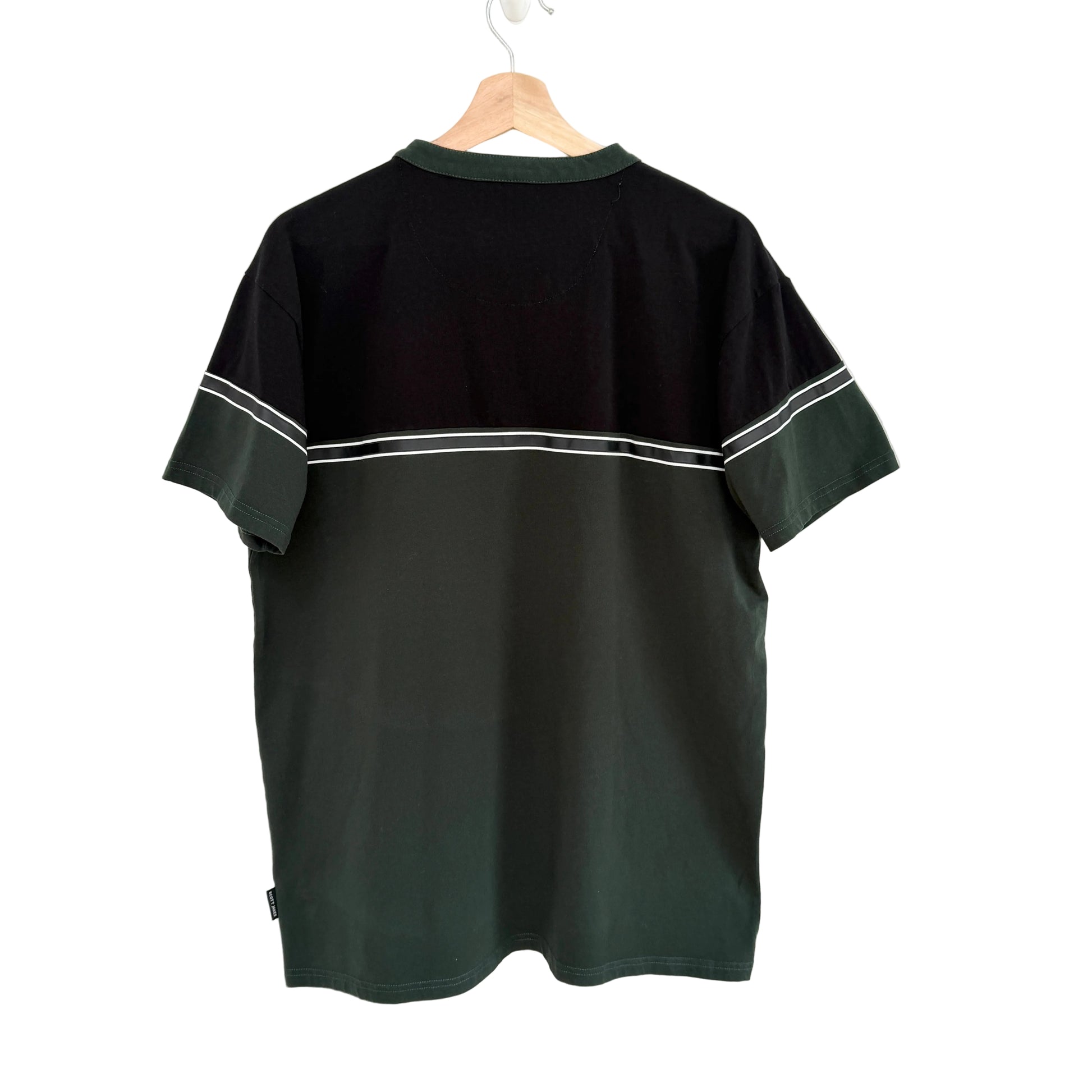 Black t-shirt with white trim on a hanger against a white background