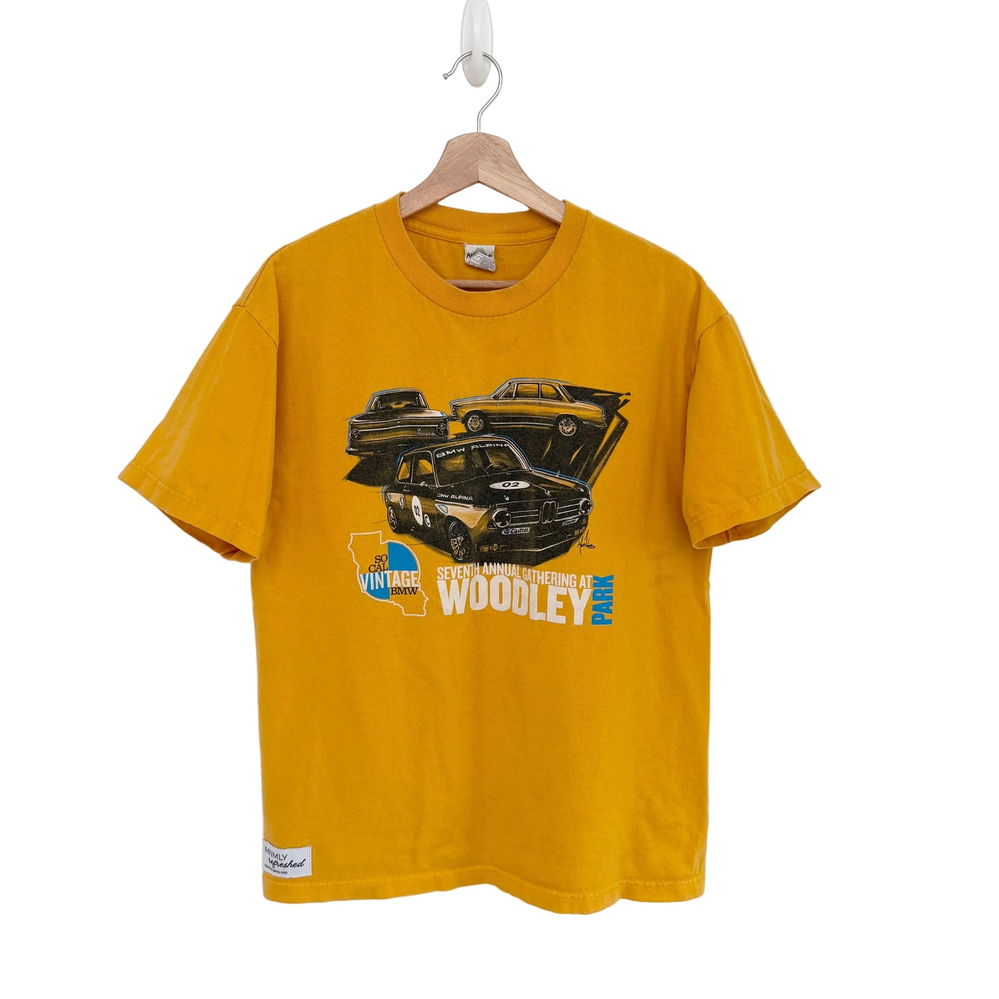 Yellow t-shirt with graphic design on a hanger against a white background