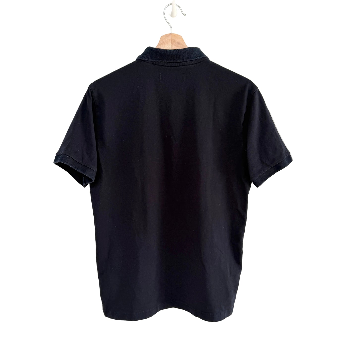 Navy polo shirt on a hanger against a white background