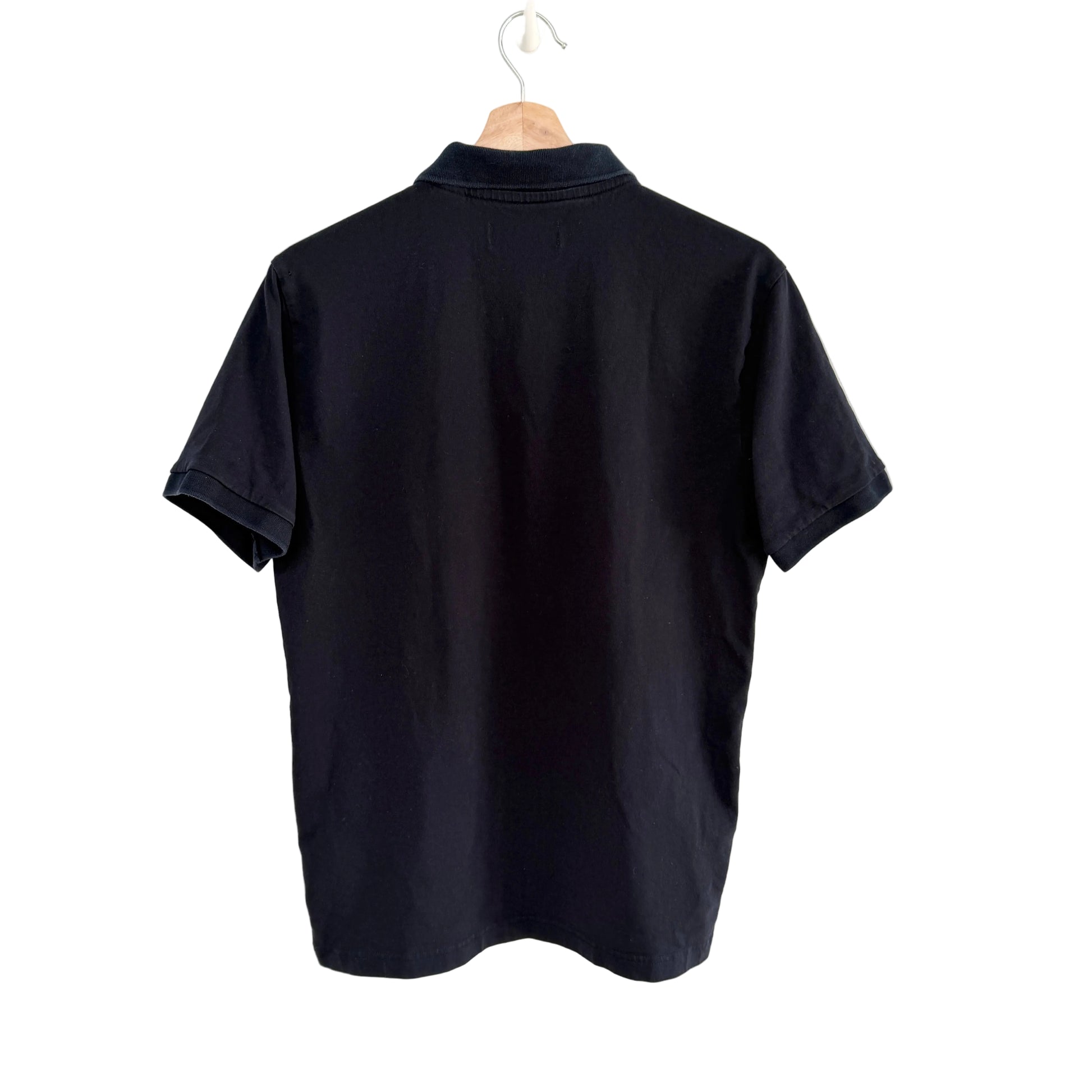 Navy polo shirt on a hanger against a white background