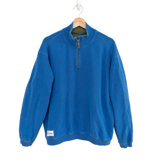 Blue sweater with a zipper on a hanger against a white background