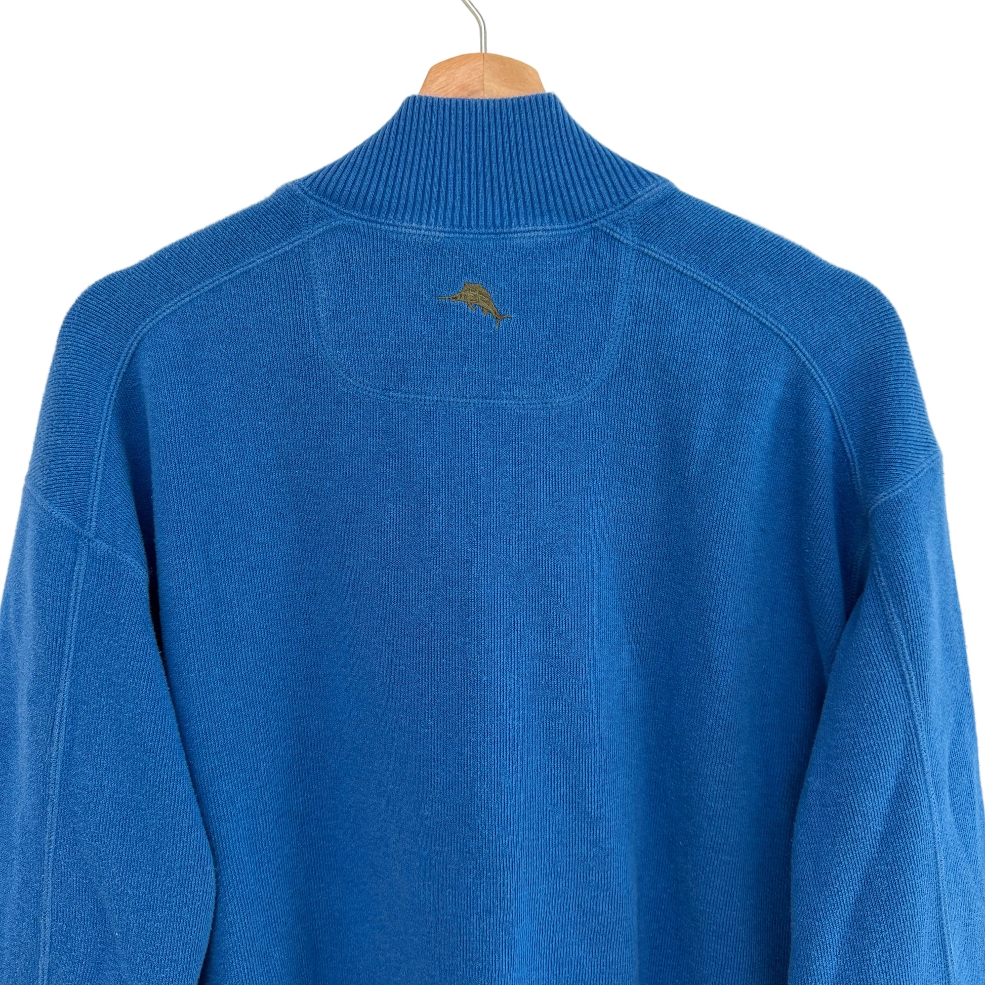 Blue sweater on a hanger against a white background