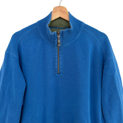 Blue sweater with a quarter zip on a wooden hanger against a white background