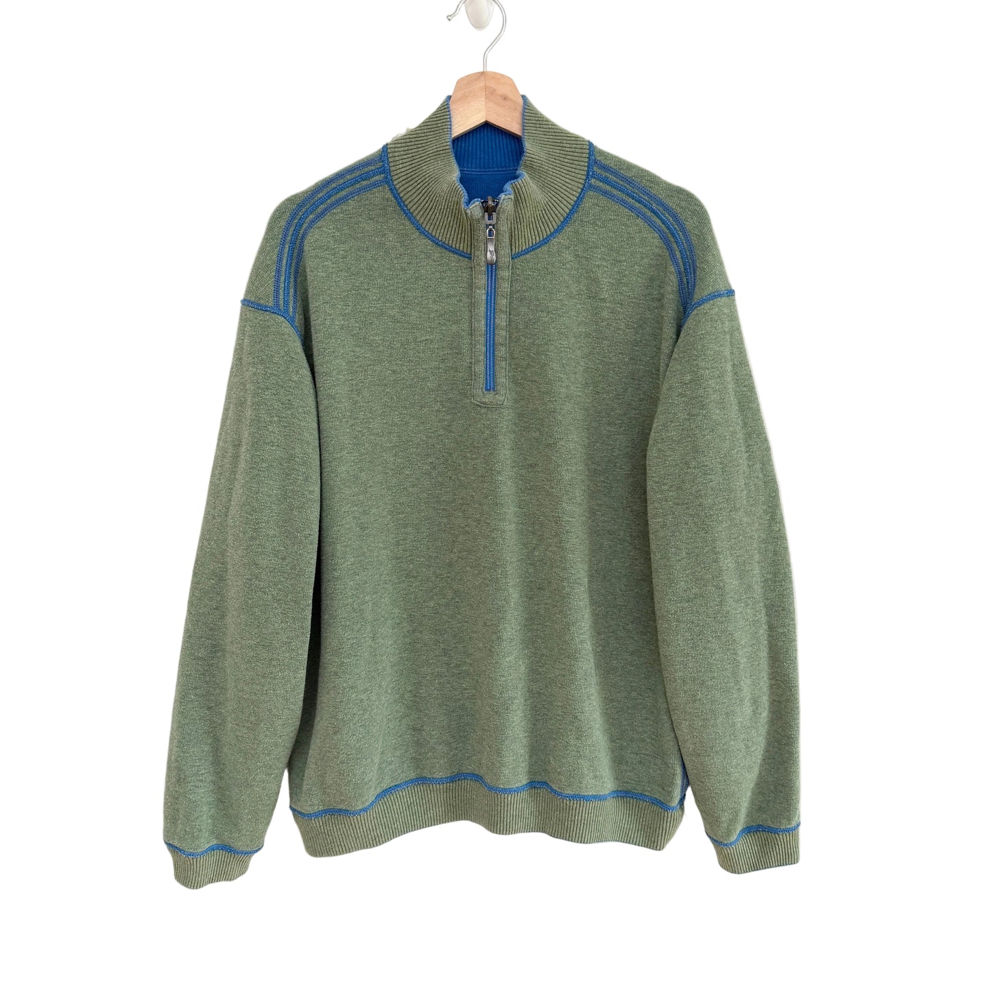Green sweater with blue accents on a white background