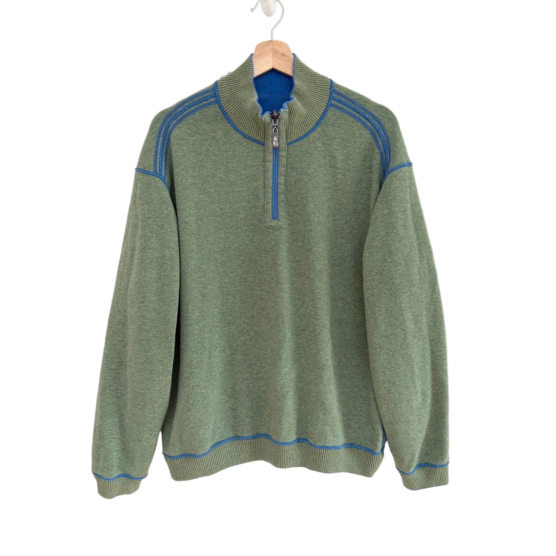 Green sweater with blue accents on a white background