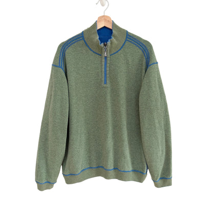 Green sweater with blue accents on a white background