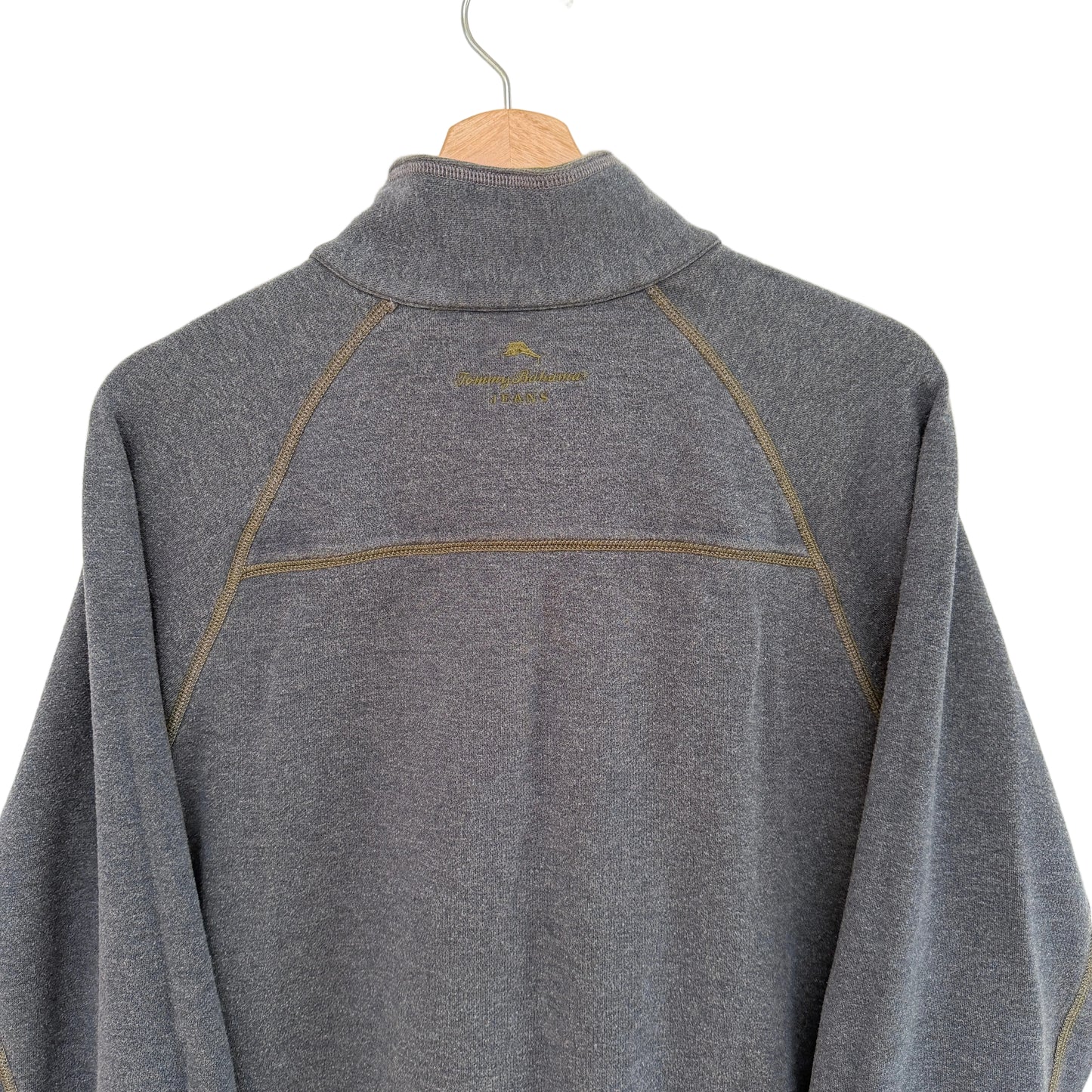 Gray pullover with a brand logo on a wooden hanger against a white background