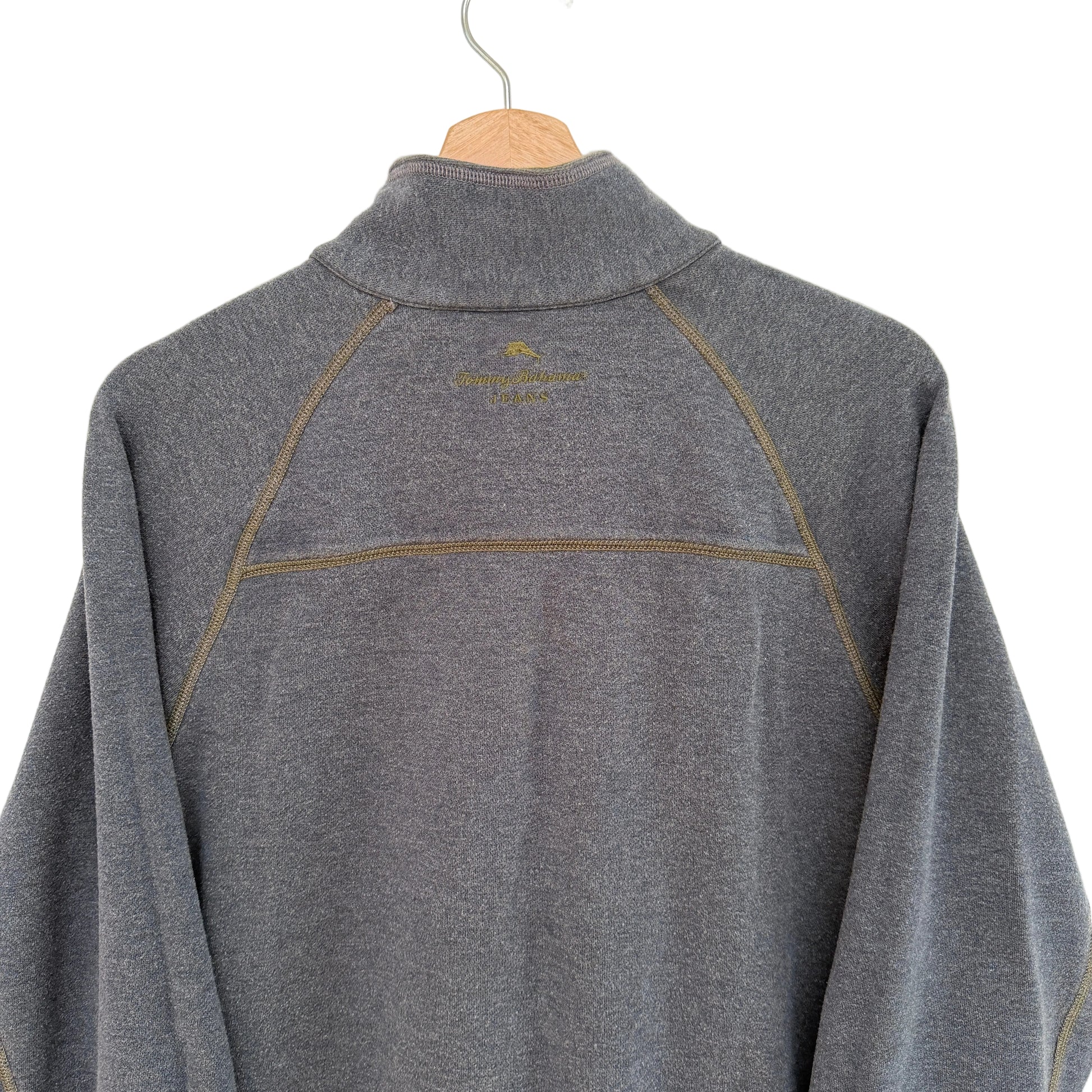 Gray pullover with a brand logo on a wooden hanger against a white background