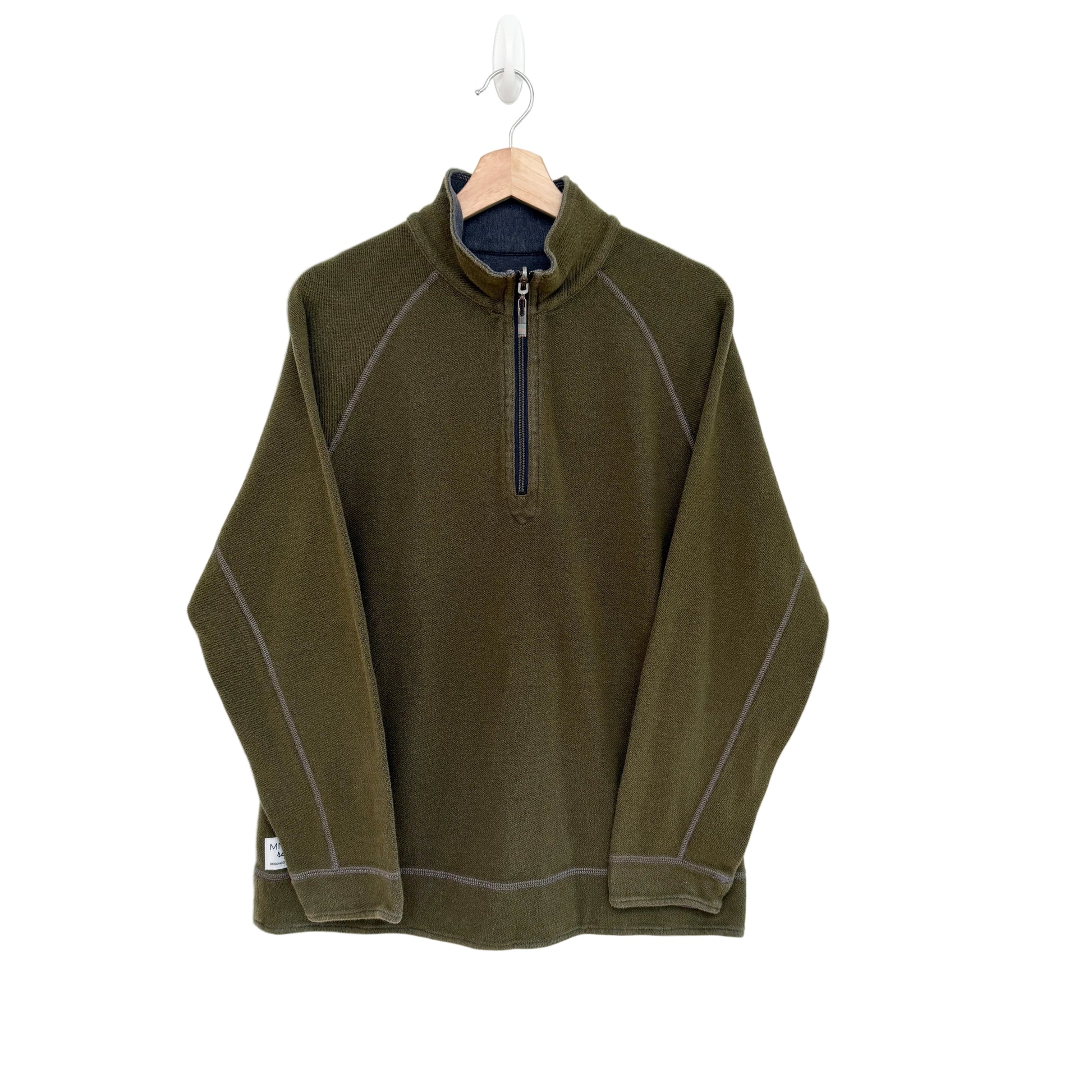 Green 1/4 zip pullover on a hanger against a white background