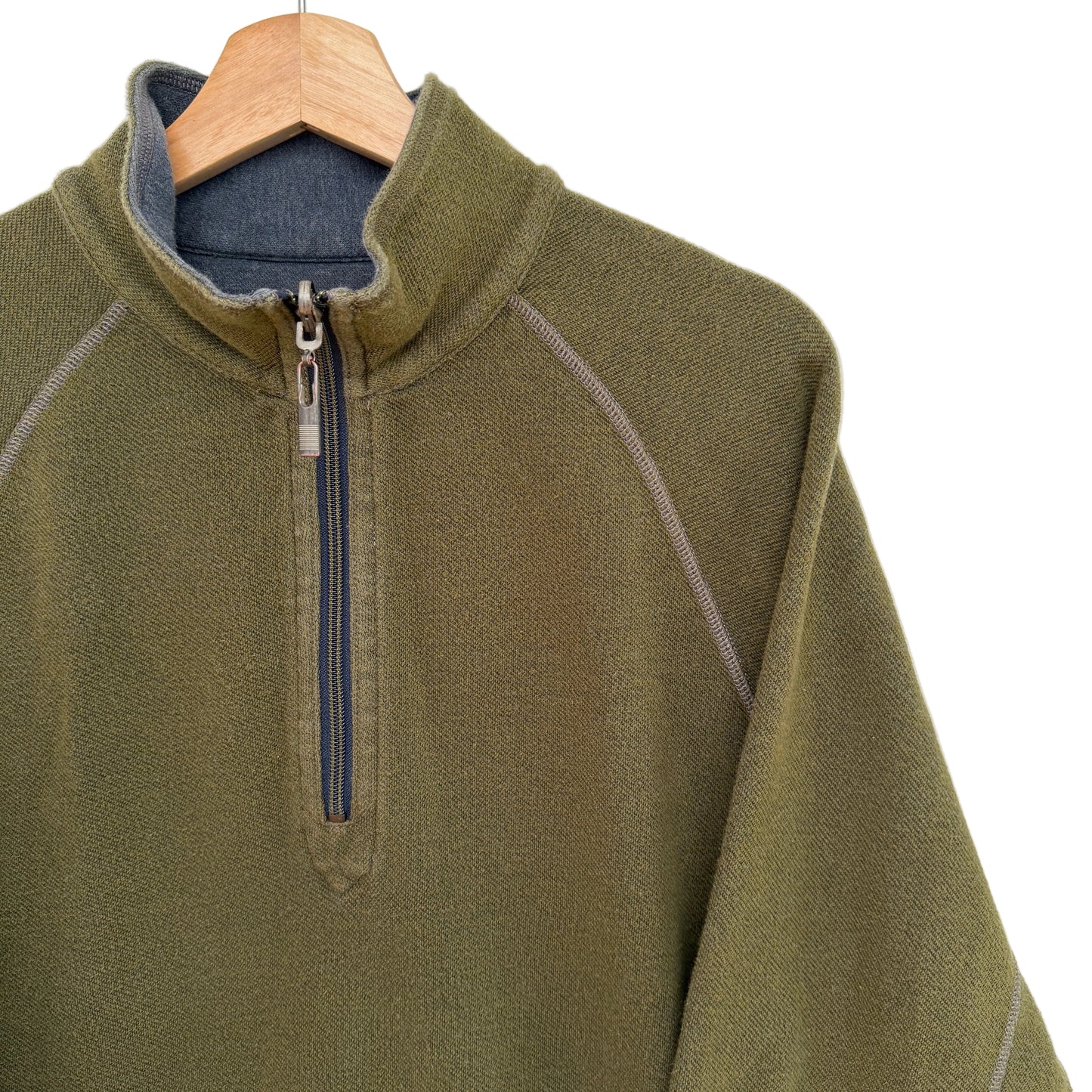 Green pullover with a quarter zip on a wooden hanger against a white background