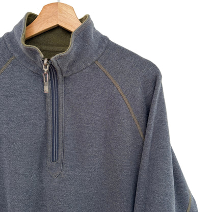 Gray pullover with a quarter zip on a wooden hanger against a light gray background