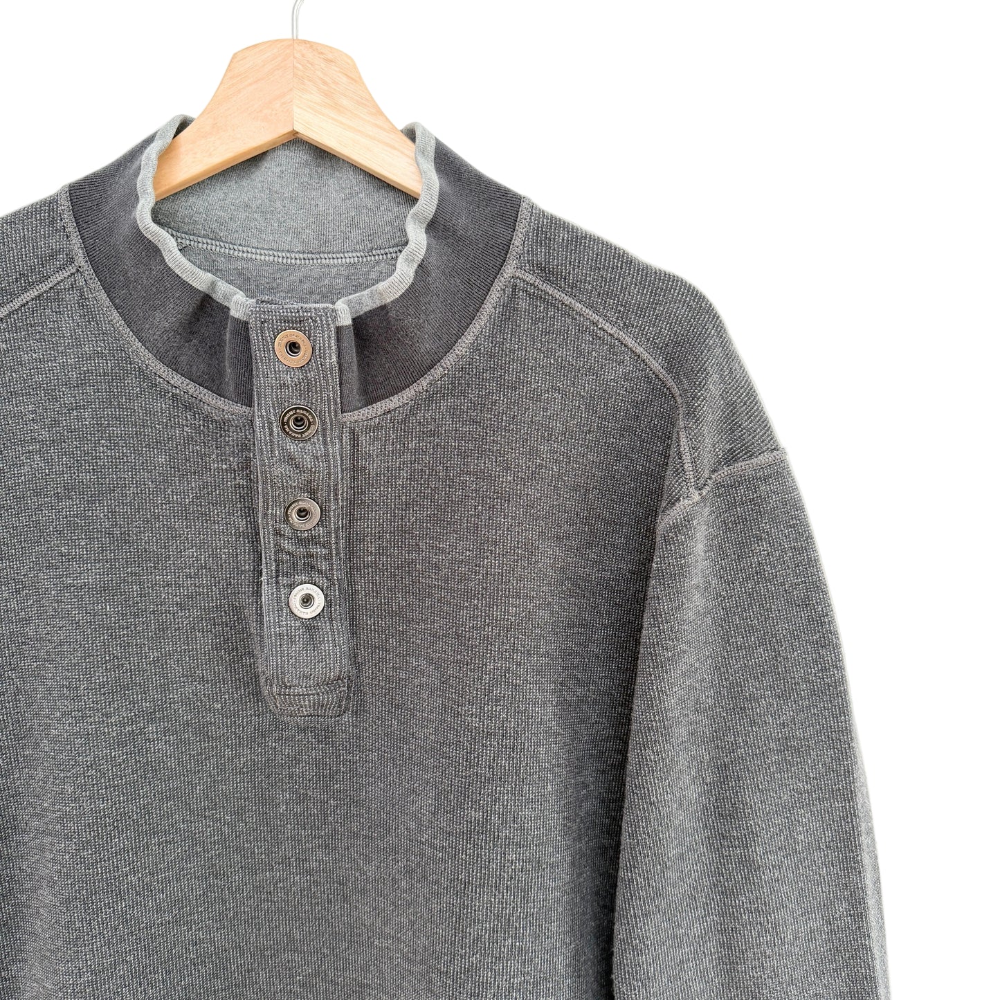 Gray henley shirt on a wooden hanger against a white background