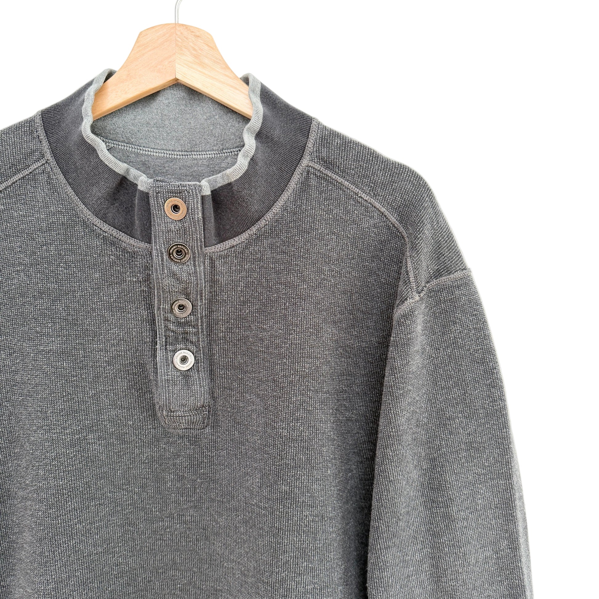 Gray henley shirt on a wooden hanger against a white background