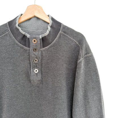 Gray henley shirt on a wooden hanger against a white background